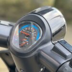 Close-up van het dashboard van een scooter met snelheidsmeter en brandstofmeter.