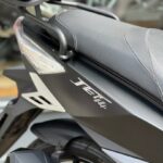 Close-up van de zijkant van een zwarte scooter met zadel, grijphandvat en JET14-logo.