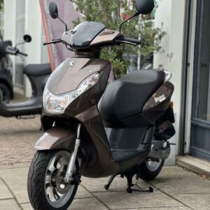 Bruine Peugeot Kisbee scooter geparkeerd op standaard voor een winkelpui.