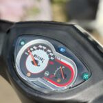 Close-up van het dashboard van een scooter met snelheidsmeter, brandstofmeter en kilometerteller op 10019 km.