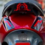 Achterkant van rode scooter met opvallende rode LED-achterlichten en carbonlook paneel