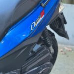 Close-up van de zijkant van een blauwe scooter met Orbit III-logo en zwart zadel.