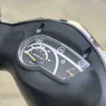 Close-up van het dashboard van een scooter met snelheidsmeter en brandstofmeter.