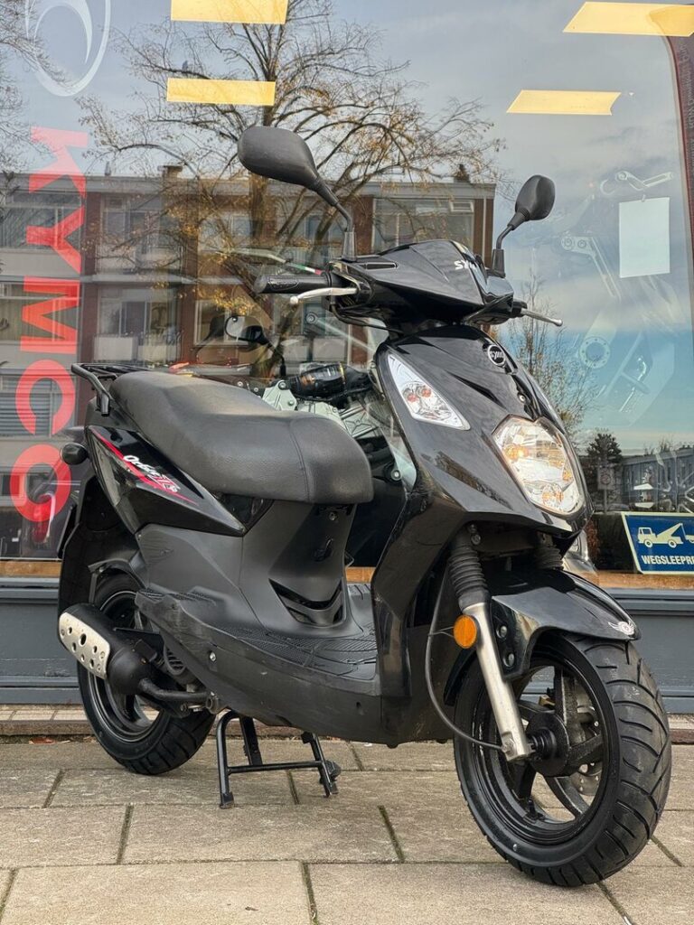 Zwarte scooter op middenbok voor een winkelruit met weerspiegeling