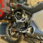 Achterzijde van een moderne elektrische motorfiets met schijfrem en achtervering, in zonlicht