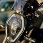 Close-up van de koplamp en het windscherm van een Super Soco elektrische motorfiets.