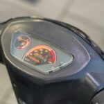 Close-up van het dashboard van een scooter met snelheidsmeter en brandstofmeter.