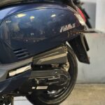 Close-up van de achterzijde van een donkerblauwe Fiddle III scooter op standaard.