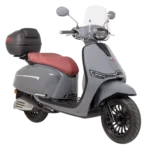 Grijze retro-stijl scooter met rood zadel, windscherm, topkoffer en LED-koplamp op witte achtergrond.