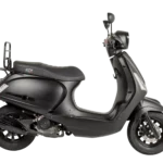 Mat zwarte retro-scooter in zijaanzicht op witte achtergrond, met GTS-logo en bagagedrager achter.