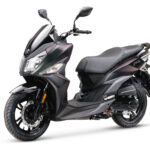 Zwarte, sportieve motorscooter in zijaanzicht op een witte achtergrond.