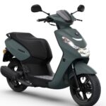 Matgroene stadsscooter in zijvoorzicht, met koplamp, zwart zadel en sportieve velgen.