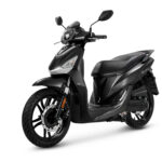 Zwarte moderne scooter met schijfrem voor, driekwart zijaanzicht op witte achtergrond.