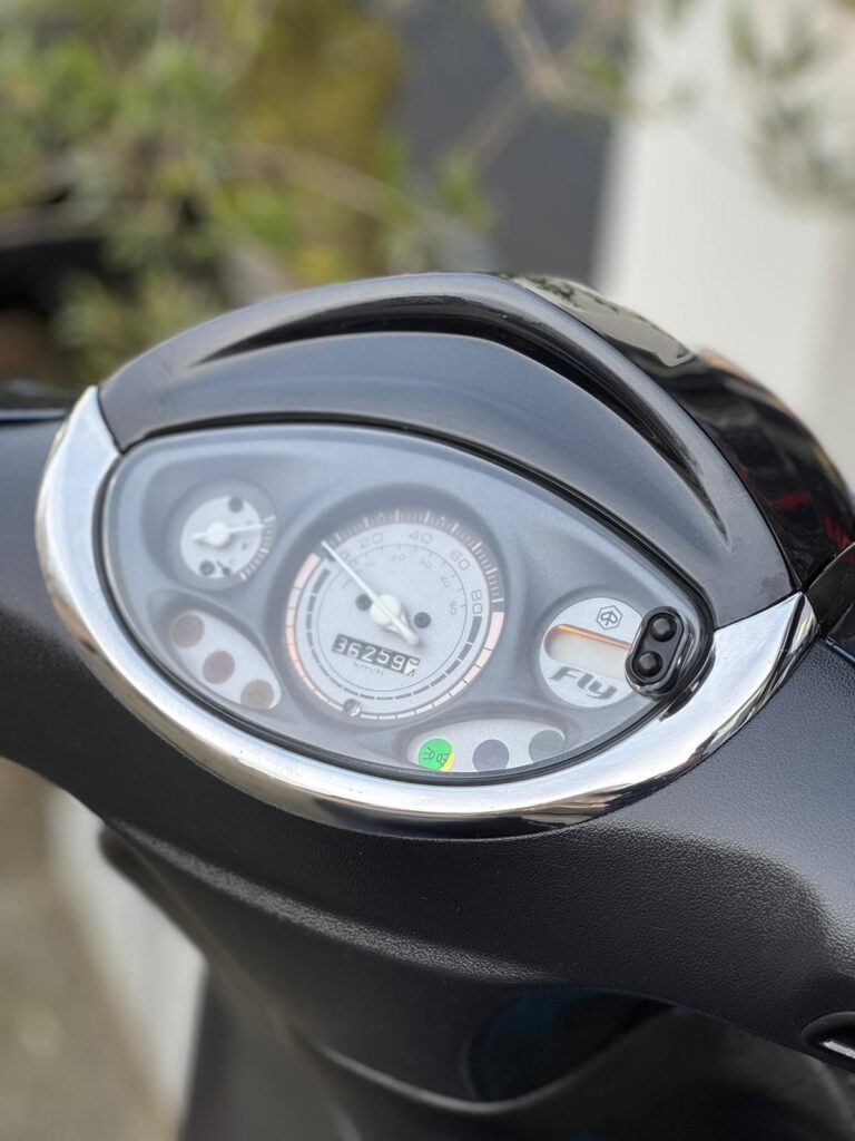 Close-up van het scooterdashboard met snelheidsmeter en kilometerteller op 36.259 km