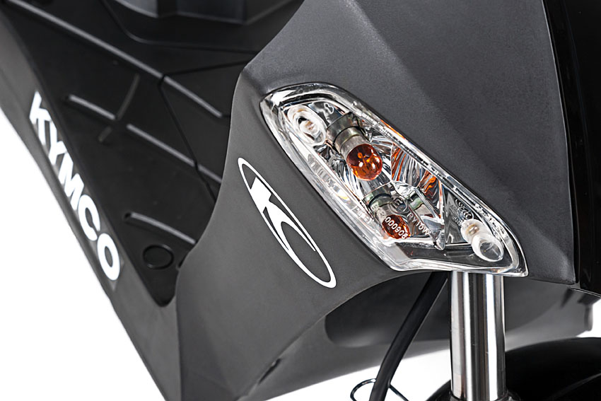 Close-up van de voorste richtingaanwijzer van een zwarte Kymco-scooter