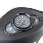 Close-up van het dashboard van een scooter met snelheidsmeter, brandstofmeter en indicatorlampjes.