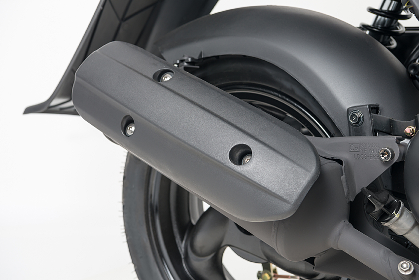 Close-up van de uitlaat en achterwiel van een scooter, mat zwarte afwerking.