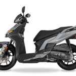 Moderne grijze scooter in zijaanzicht op witte achtergrond, met zwarte velgen en schijfrem.