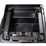 Lege zwarte kunststof opbergbak onder het zadel van een scooter, bovenaanzicht.