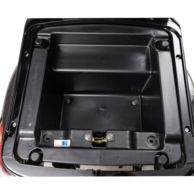 Lege zwarte kunststof opbergbak onder het zadel van een scooter, bovenaanzicht.