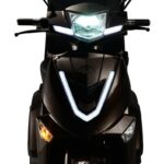 Vooraanzicht van een scooter met felle LED-koplamp en V-vormige dagrijverlichting.