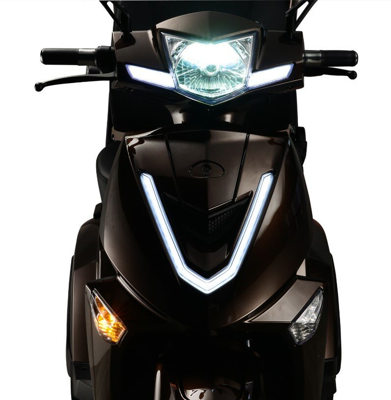 Vooraanzicht van een scooter met felle LED-koplamp en V-vormige dagrijverlichting.