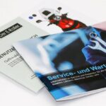 Twee gedrukte handleidingen en servicebrochures voor e-scooters, met blauw omslag en foto van een rode scooter.