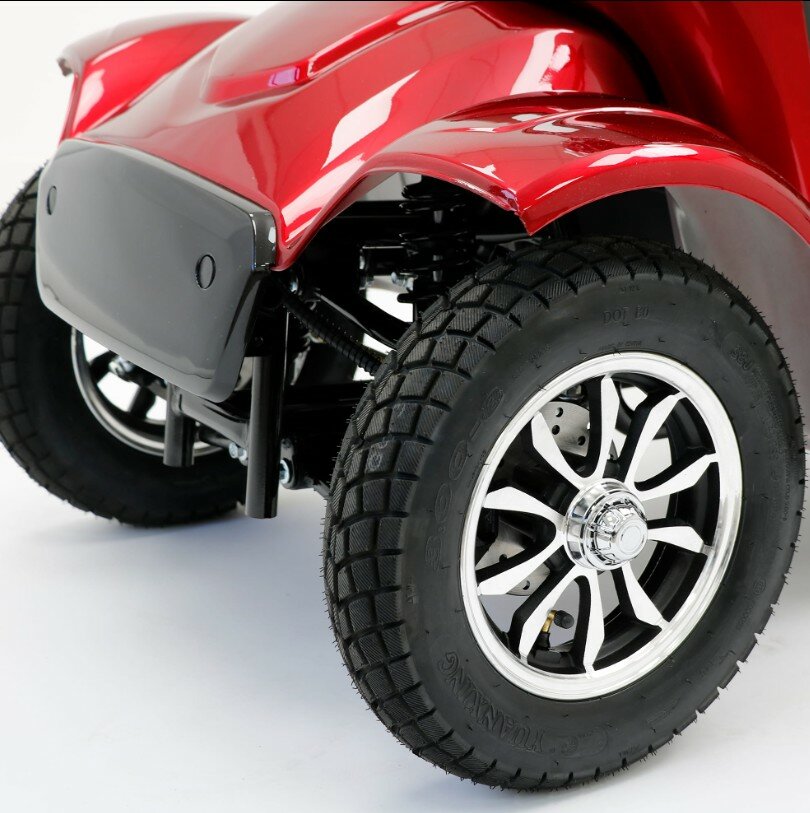 Close-up van het voorwiel met profielband en chroomvelg onder een rood spatbord.