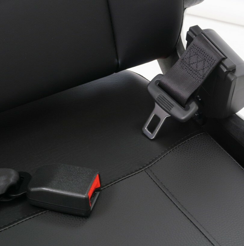 Close-up van een autogordel met gesp op een zwarte leren autostoel.