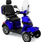 Blauwe vierwielige scootmobiel met windscherm, comfortabele stoel en opbergkoffer.