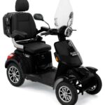 Zwarte vierwielige scootmobiel met comfortabele stoel, armsteunen, koffer en windscherm.