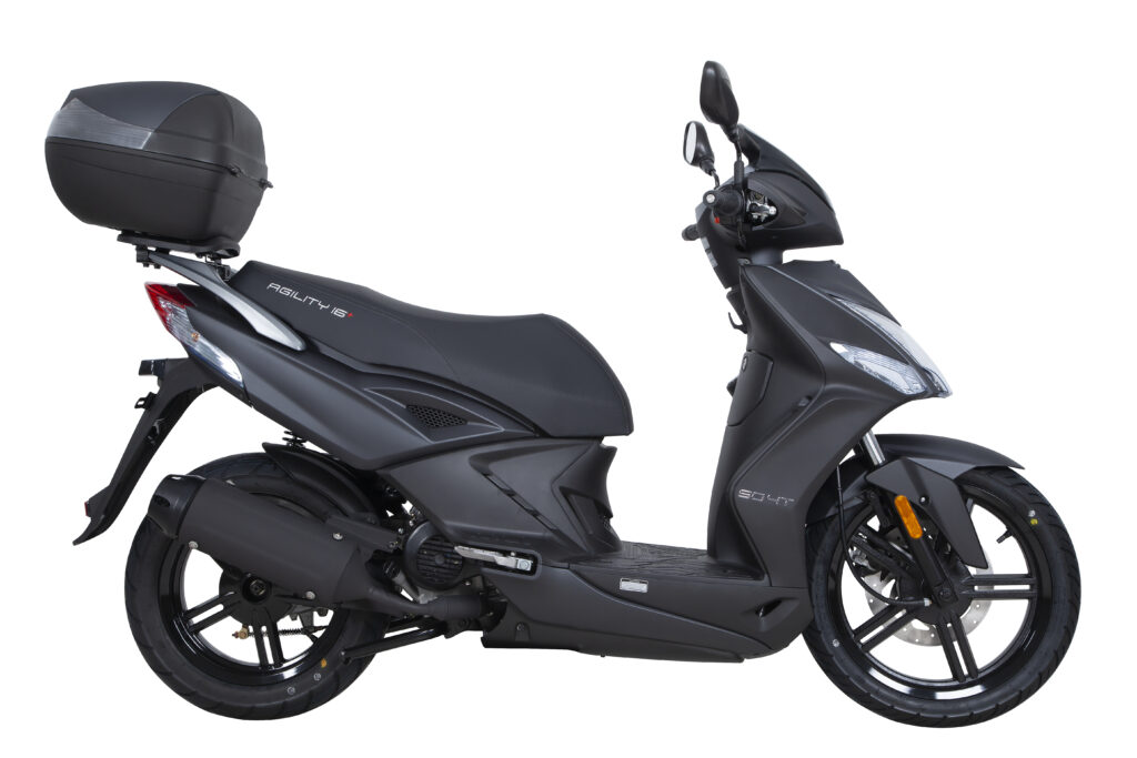 Mat zwarte scooter met topkoffer, zijaanzicht op witte achtergrond.