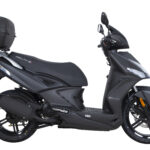 Mat zwarte scooter met topkoffer, zijaanzicht op witte achtergrond.