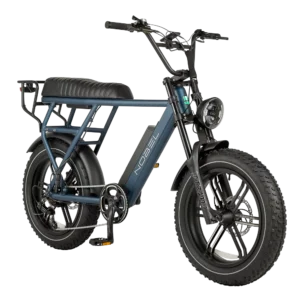 Blauwe elektrische fatbike met brede banden, lang zadel, ronde koplamp en achterdrager op witte achtergrond.