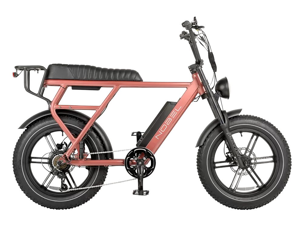 Roze moped-stijl e-bike met dikke banden, lange zadelbank, spatborden, bagagedrager, voorlamp en accu op het frame.