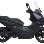 Mat zwarte motorscooter met hoge ruit, zijaanzicht op witte achtergrond.