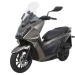 Moderne bronsgrijze maxi-scooter met hoog windscherm en schijfrem, schuin van voren op witte achtergrond.