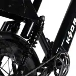 Close-up van achtervering en aandrijving van een zwarte elektrische fiets.