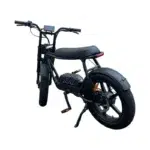 Zwarte e-bike in brommerstijl met dikke banden, lang zadel, display en schijfrem, op zijstandaard