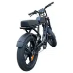 Zwarte e-bike met brommerstijl, dikke banden, lang zadel en spatborden, schuin van achteren gezien.