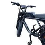 Close-up van een zwarte elektrische fiets met dik voorwiel, display en lang zadel.