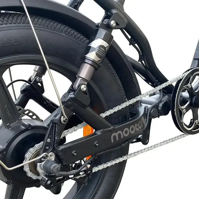 Close-up van de achtervering, ketting en schijfrem van een elektrische fiets.