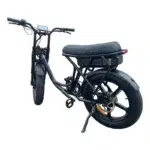 Zwarte fat-tire e-bike met lang zadel, achteraccu, schijfrem en LCD-display, op zijstandaard.