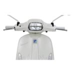 Frontale close-up van een witte retro scooter met stuur, spiegels en rechthoekige koplamp.