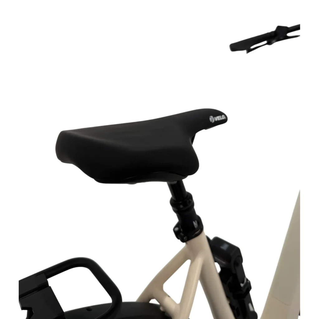 Close-up van een zwart fietszadel op een beige e-bike, met zadelpen en bagagedrager.
