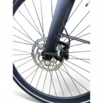 Close-up van een fietsvoorwiel met schijfrem, rotor en zwarte voorvork op witte achtergrond.