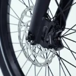 Close-up van Tektro schijfrem met remklauw op het voorwiel van een moderne fiets.