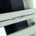 Close-up van een wit apparaat met de opdruk 'WONDER' op een horizontale balk.