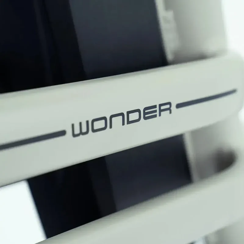Close-up van een wit apparaat met de opdruk 'WONDER' op een horizontale balk.