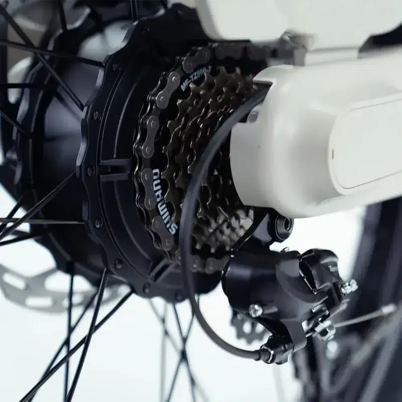 Close-up van een e-bike achterwiel met naafmotor, cassette, ketting en derailleur.